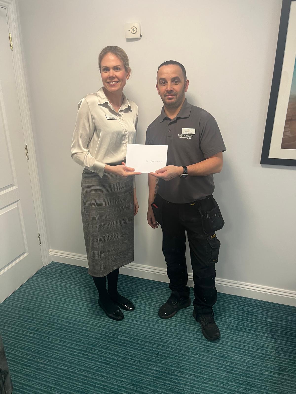 General Manager Elina House presents the £100 voucher as way of a thank you for all the staffs hard work and dedication to the home.