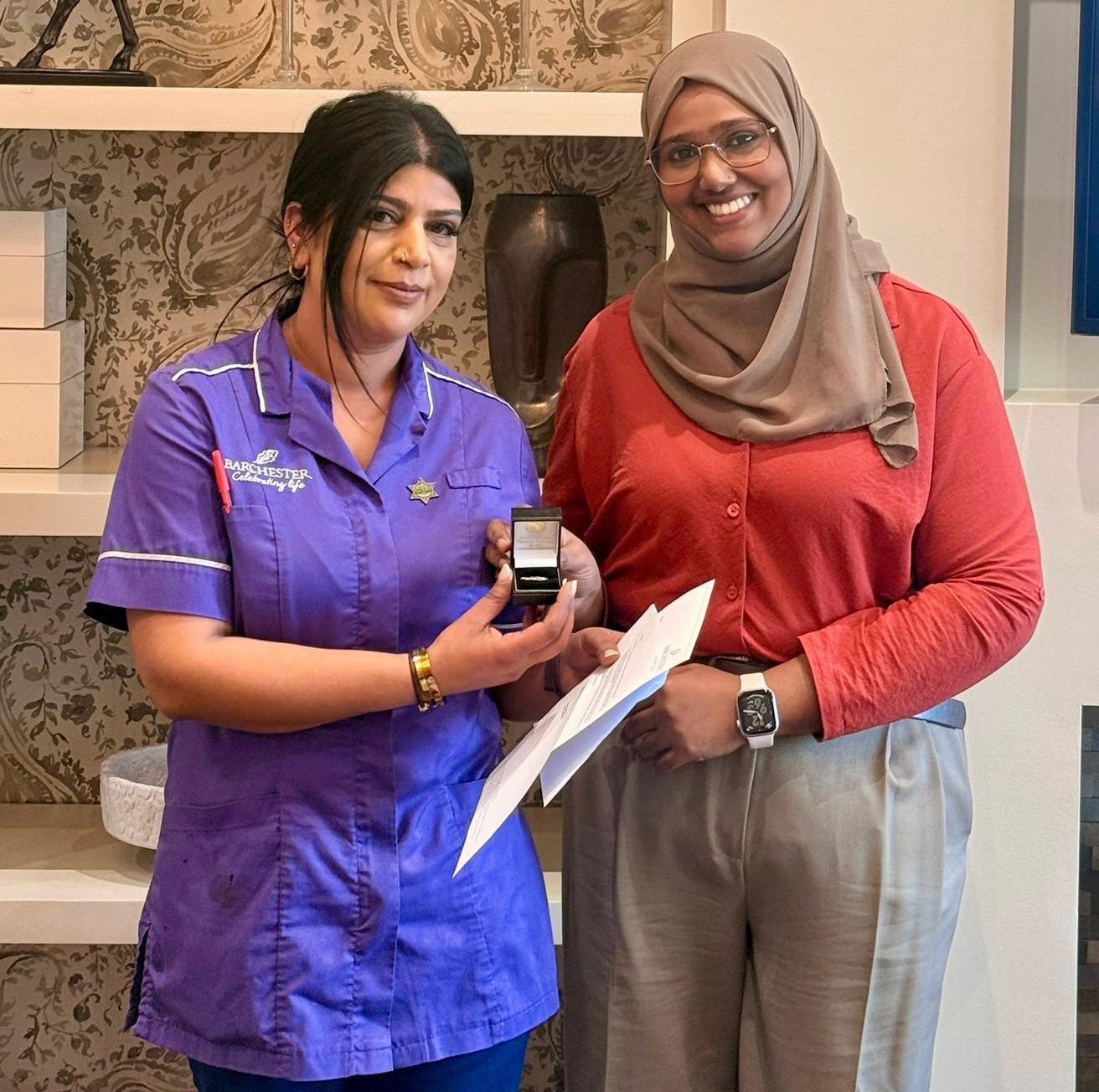 Snobia receives her 10 year service award pin from General Manager Benazir Shakkir