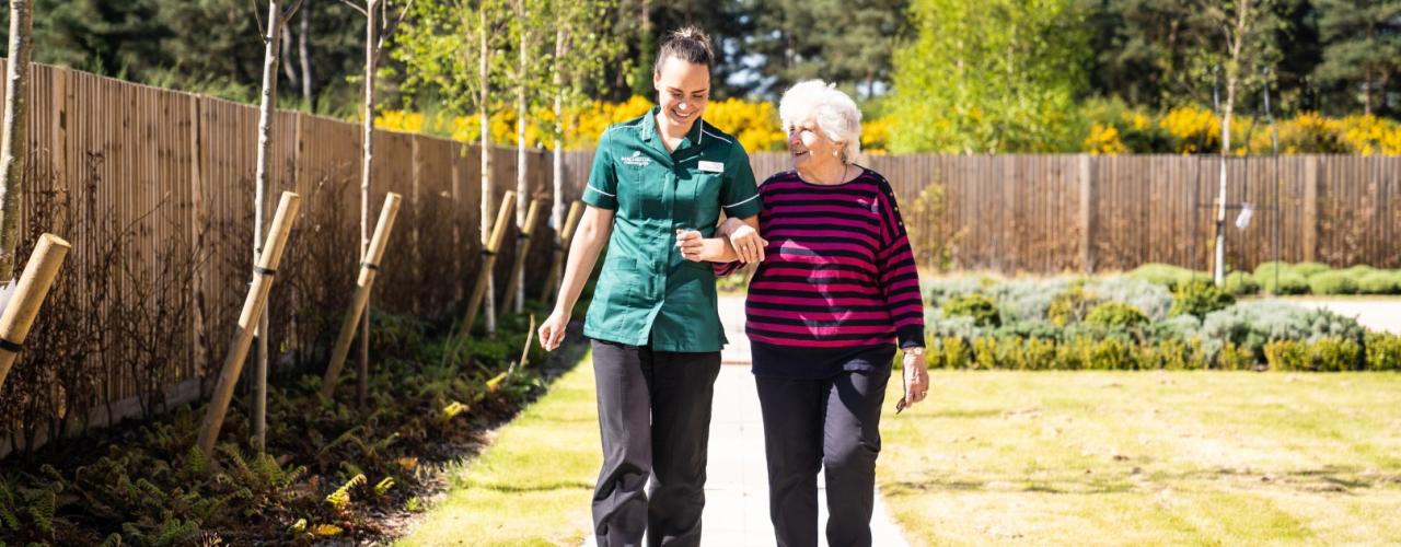 Staff and Resident walking in the garden 