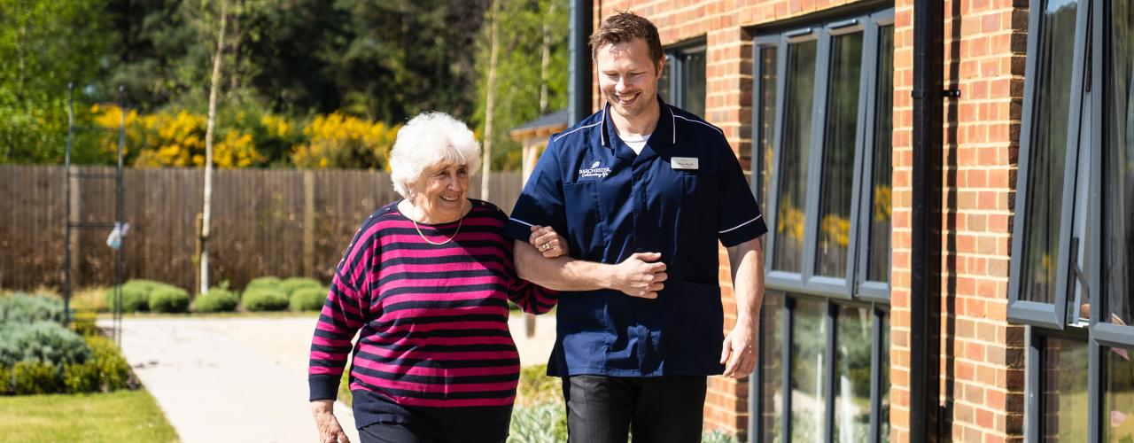 Resident and carer linking arms