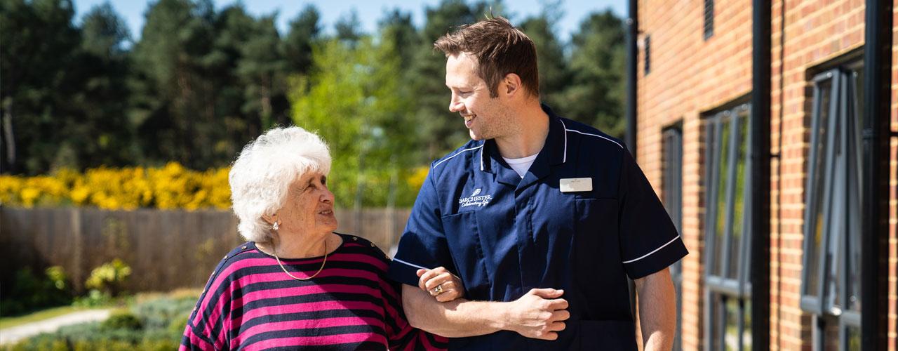 Resident walking with Barchester carer