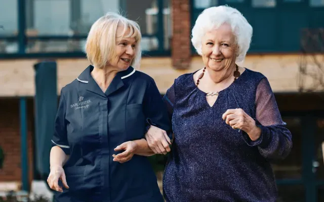 A nurse walking with a resident 