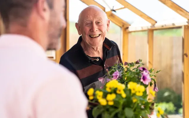 Resident smiling with flowers