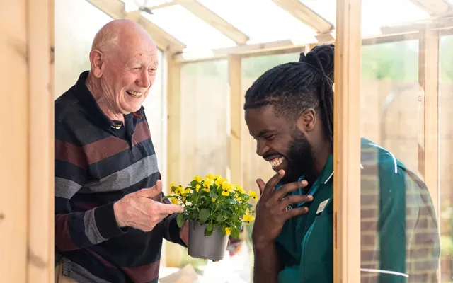 Resident laughing whilst gardening 