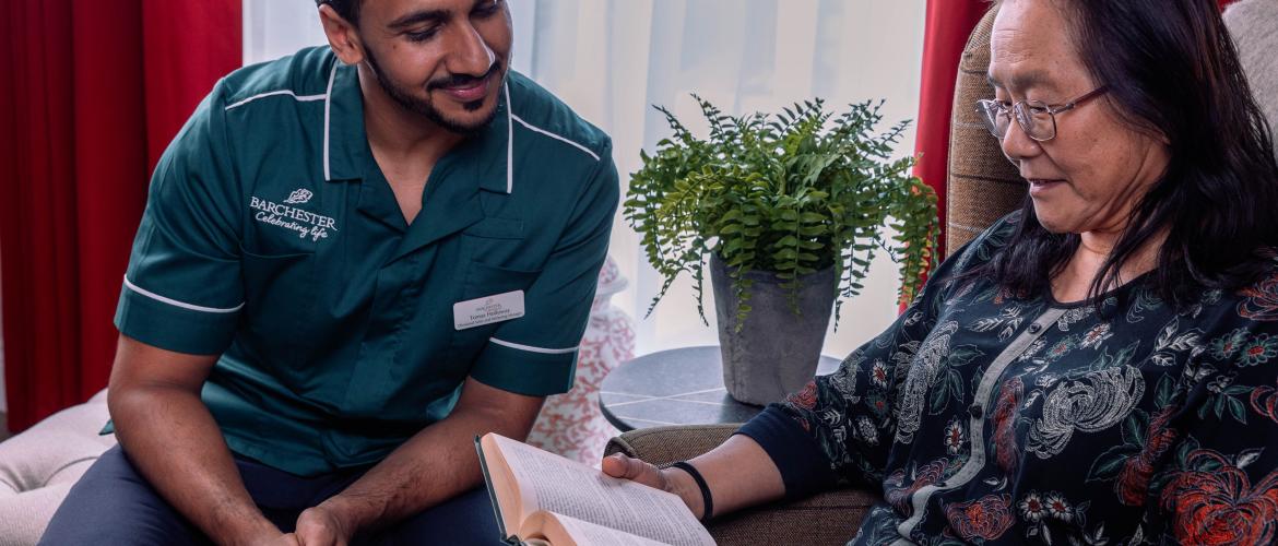 Carer and Resident reading a book