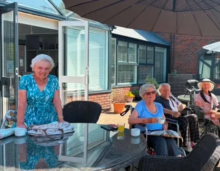 Residents sitting in the garden enjoying watching the cricket 