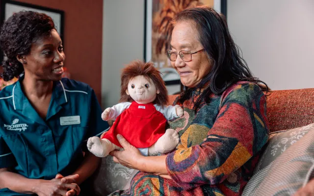 Carer with resident holding a dementia doll