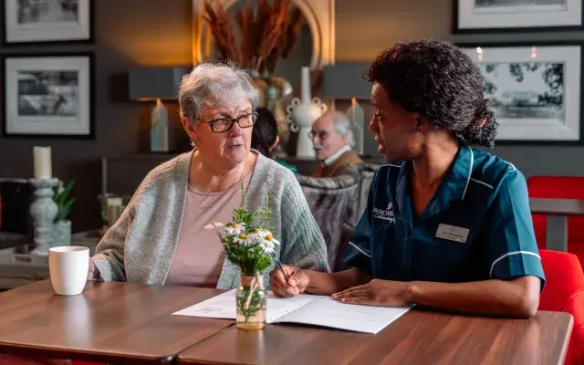 Carer with resident reviewing a check-list