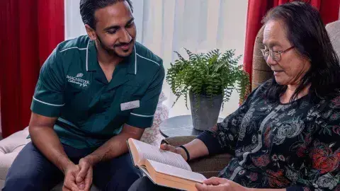 Carer and Resident reading a book