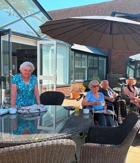 Residents sitting in the garden enjoying watching the cricket 